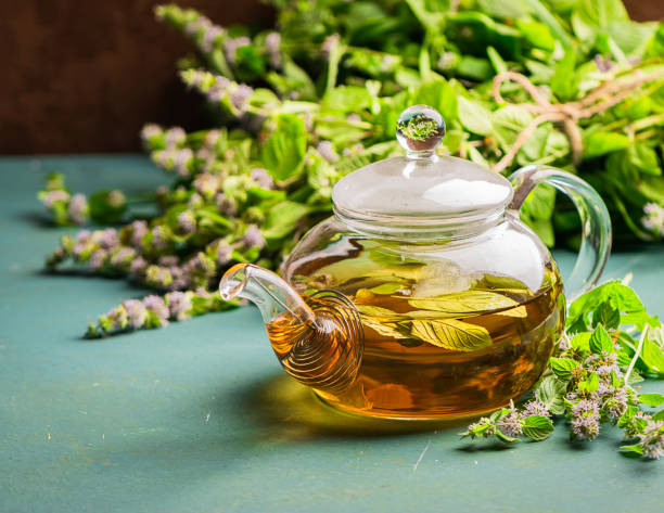 istock Fresh aromatic tea with melissa mint leaves glass teapot on a rustic background. Healing herbal drink. Horizontal frame. 1168204996