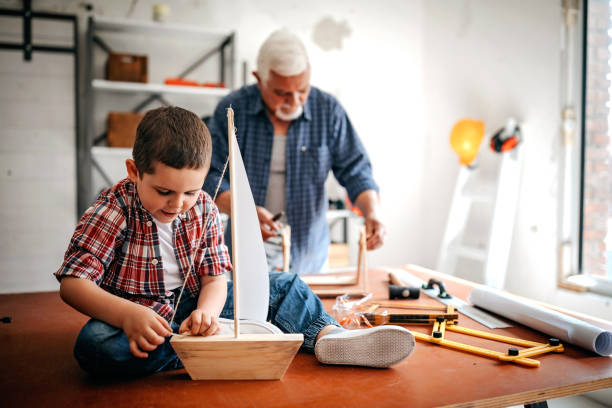 We gonna make it Grandfather and grandson making ship at home toy boat stock pictures, royalty-free photos & images