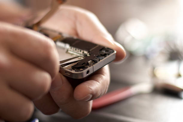 Miniature people. Business men stand near disassembled parts of an electronic device. Business entrepreneur concept