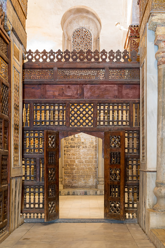 Pared de madera intercalada (mashrabiya) con puerta ornamentada de madera photo