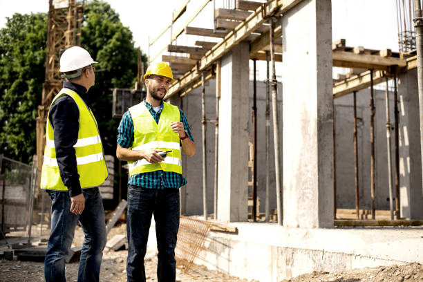 istock Men in hardhat and green jacket posing on building site. 1168210961