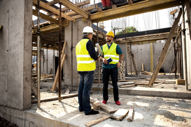 istock Men in hardhat and green jacket posing on building site. 1168210968