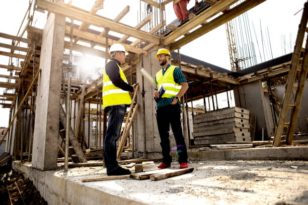 istock Men in hardhat and green jacket posing on building site. 1168211809