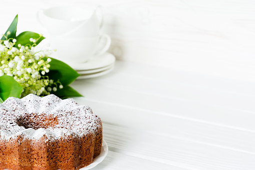 Bundt cake with sugar frosting. Spring breakfast still life Easter festive treat. bouquet of lily of the valley