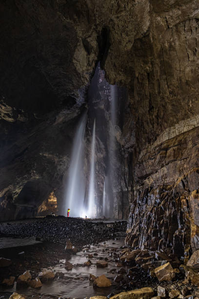 Caver in Gaping Gill Cavern Inside Gaping Gill in Yorkshire one of the UK's largest underground chambers which is accessed through a pothole 98m (322ft) deep ingleborough stock pictures, royalty-free photos & images