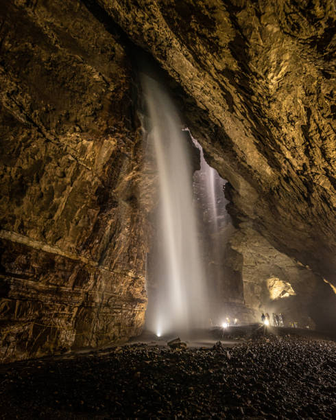 Waterfalls in Gaping Gill Inside Gaping Gill in Yorkshire one of the UK's largest underground chambers which is accessed through a pothole 98m (322ft) deep ingleborough stock pictures, royalty-free photos & images