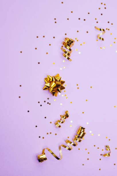 istock Golden decorations and sparkles on pale purple background 1168218630