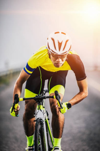 istock asian man riding bicycle on asphalt road against sunrise 1168221164