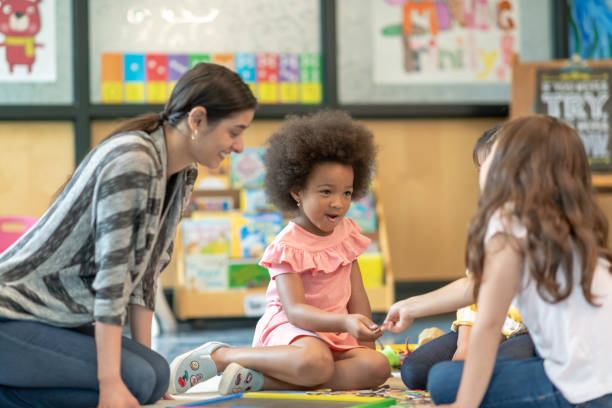 istock Preschool students playing in classroom with teacher 1168222918