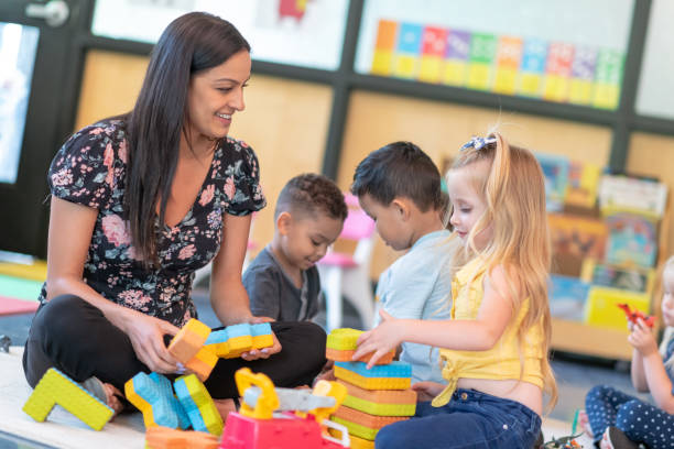 istock Preschool students playing in classroom with teacher 1168223069