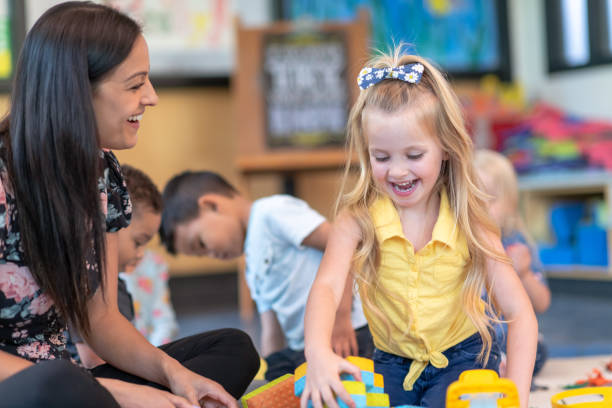 istock Preschool students playing in classroom with teacher 1168223070