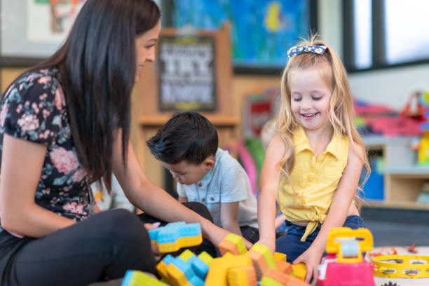 istock Preschool students playing in classroom with teacher 1168223079
