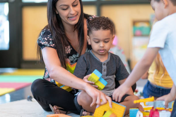 istock Preschool students playing in classroom with teacher 1168223191