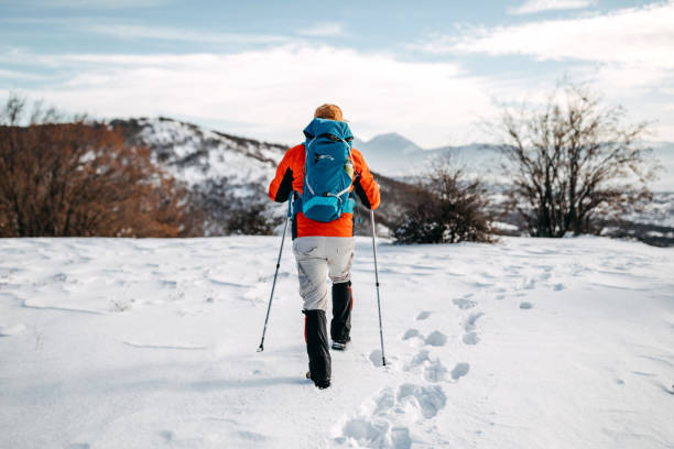 Senior man hiking on snowy mountain