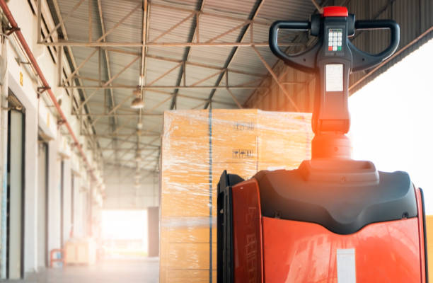 istock electric forklift pallet jack with cargo shipment pallet at distribution warehouse. 1168229639