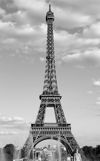 Eiffel Tower in Paris with white clouds in the sky and a black and white antique effect excellent as a postcard or vertical poster