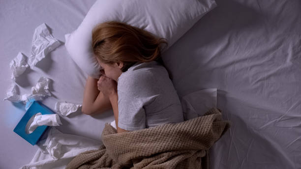 istock Lonely girl crying in her bed, many tissues lying beside, depression, top-view 1168236541