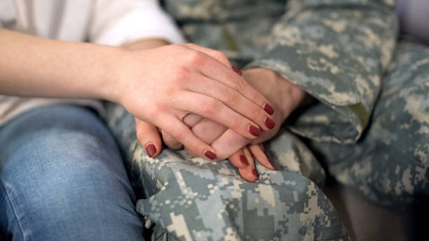 istock Military man and girlfriend holding hands, supporting boyfriend before leaving 1168236548