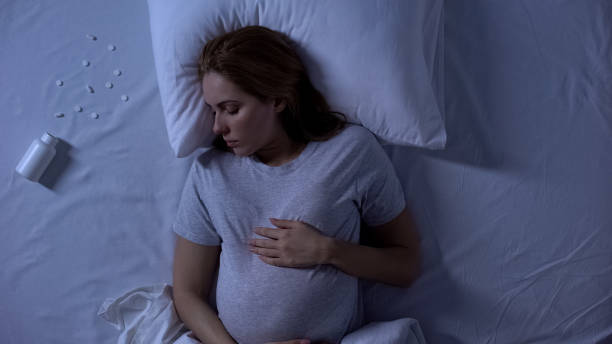 unconscious pregnant lady lying in bed, pills intoxication, suicide attempt - intoxication imagens e fotografias de stock