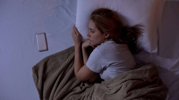 istock Lonely lady lying in bed, looking at smartphone, waiting for sms from boyfriend 1168236864