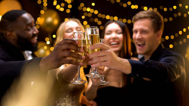 verres de boisson de cliquetis multiethniques heureux d'entreprise, célébrant le nouvel an - champagne flute champagne black wineglass photos et images de collection