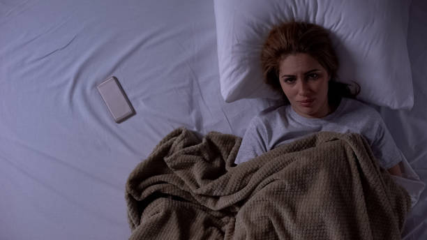 istock Sad lady lying in bed, phone beside, waiting for call from husband, break up 1168237076