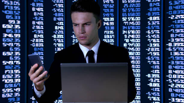 istock Man in suit with laptop checking information on smartphone, digital data 1168237115