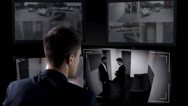 istock Male security operator watching surveillance cameras, illegal business deal 1168237335