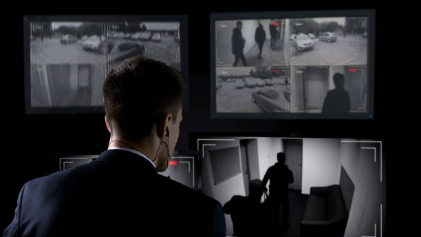 istock Security guard in earphones watching robbery attempt on surveillance cameras 1168237336