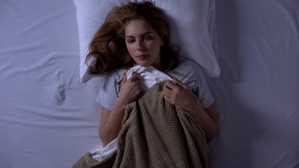 istock Attractive female lying in bed covered with blankets, feeling cold, heating end 1168238304