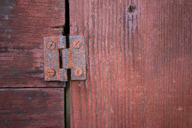 istock Macro view of rusty hinge on old wood door painted red 1168239904