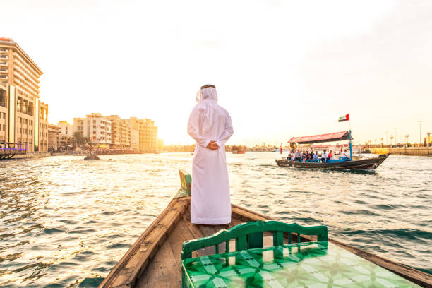 Arabian man wearing kandura on abra boat on Creek's canal in Dubai
