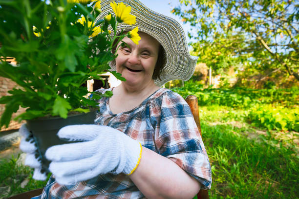 Happy woman with Down Syndrome ready to planting flowers. Gardening. Happy woman with Down Syndrome ready to planting flowers. Gardening. down syndrome photos stock pictures, royalty-free photos & images