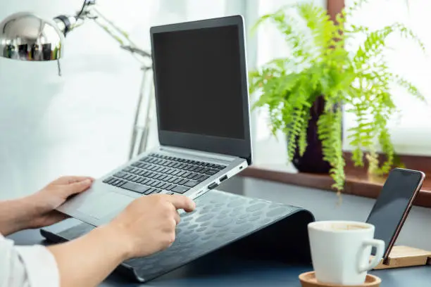 Photo of Woman puts her ultrabook to laptop's stand.