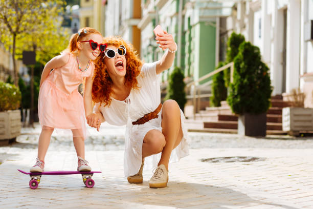 istock Joyful mom and daughter doing selfie photo 1168252755