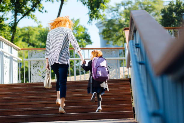 istock Delighted little girl walking with mom before lessons 1168252929