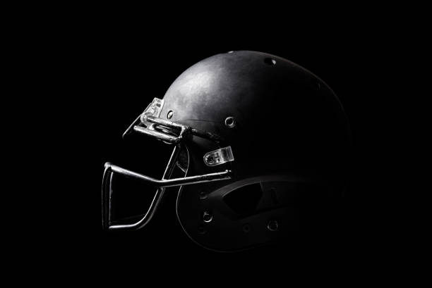 casco de fútbol sobre fondo negro. - casco de deportes fotos fotografías e imágenes de stock