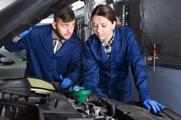 istock Female master with foreman are replacing the oil in car 1168254407