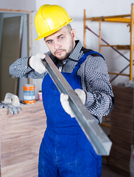 istock Professional constructor in helmet is looking at the level of the profile 1168254622
