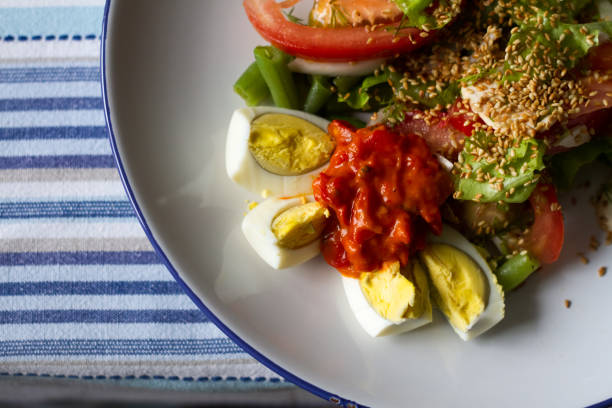 pequeno almoço da vista superior em uma tabela de madeira clara, salada com tomates e manjericão, ovos e café cozidos, conceito comendo saudável, foco seletivo - butter dairy product butter dish milk - fotografias e filmes do acervo