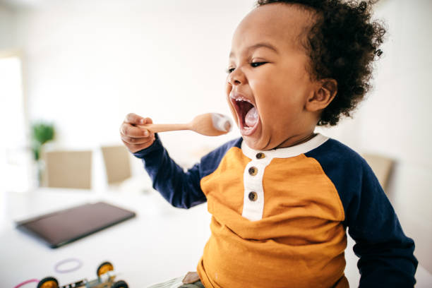 enfant en bas âge mangeant le yaourt - baby food photos et images de collection