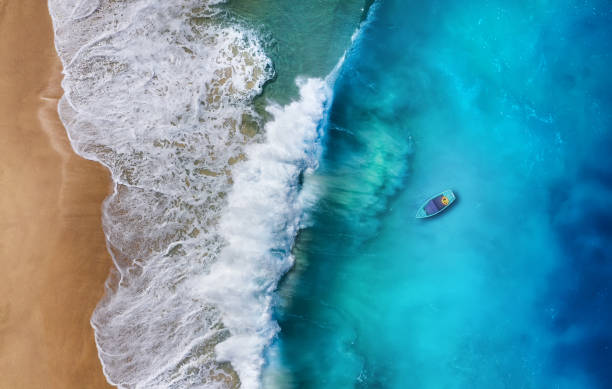 istock Boat on the water surface from top view. Turquoise water background from top view. Summer seascape from air. Travel - image 1168257020