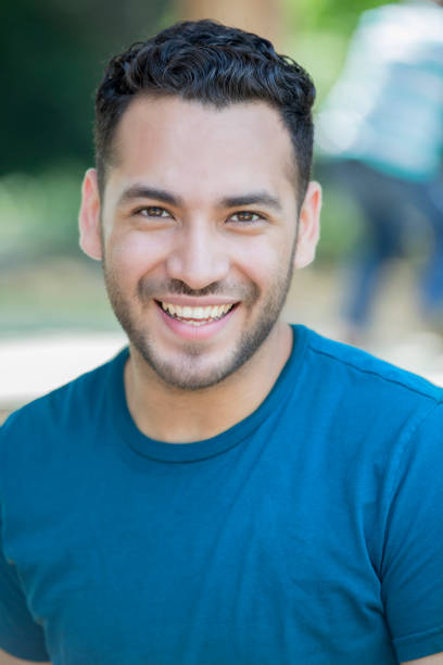 istock Young Hispanic man smiles while sitting outdoors 1168257183
