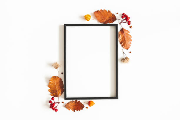 Photo of Autumn composition. Photo frame, flowers, leaves on white background. Autumn, fall, thanksgiving day concept. Flat lay, top view, copy space