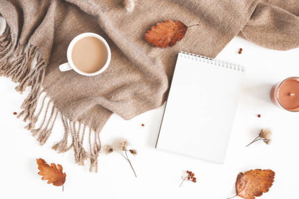 istock Autumn composition. Cup of coffee, plaid, notepad, autumn leaves on white background. Flat lay, top view, copy space 1168259593
