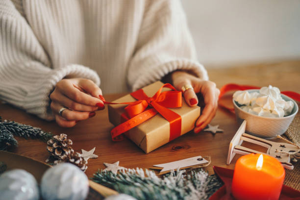 femme emballant des cadeaux de noel à la maison - christmas paper bow white christmas photos et images de collection
