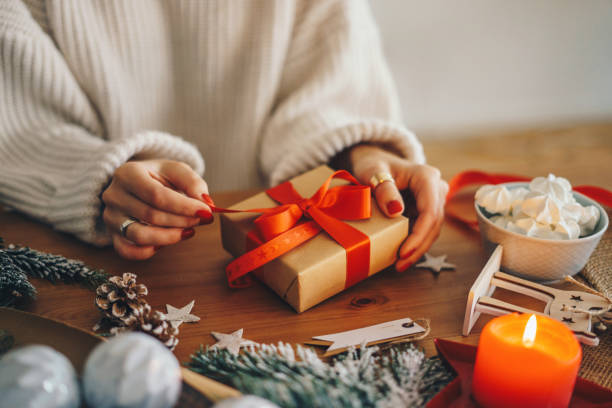 Woman wrapping Christmas presents at home Woman wrapping Christmas gifts red nail polish stock pictures, royalty-free photos & images