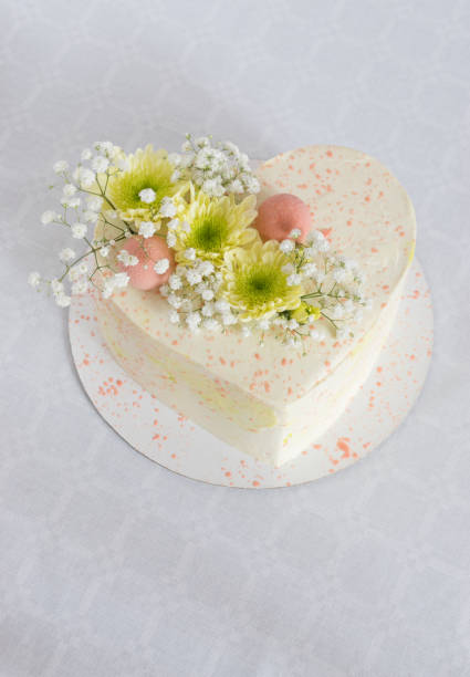 istock Heart-shaped cake decorated with fresh flowers on a white tablecloth 1168260918