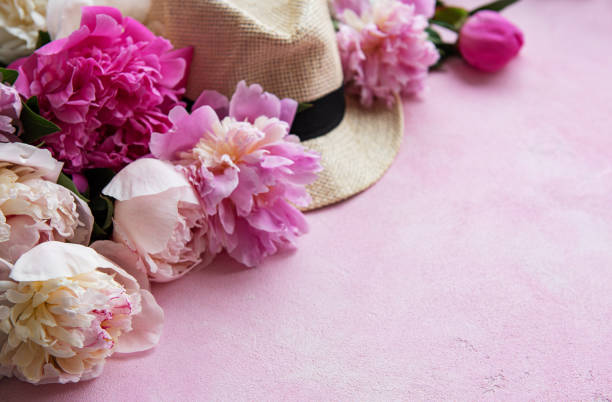 istock Pink peonies and hat on a pink concrete background 1168262750