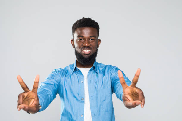 istock African young man happy expression and peace gesture isolated on gray background 1168262886